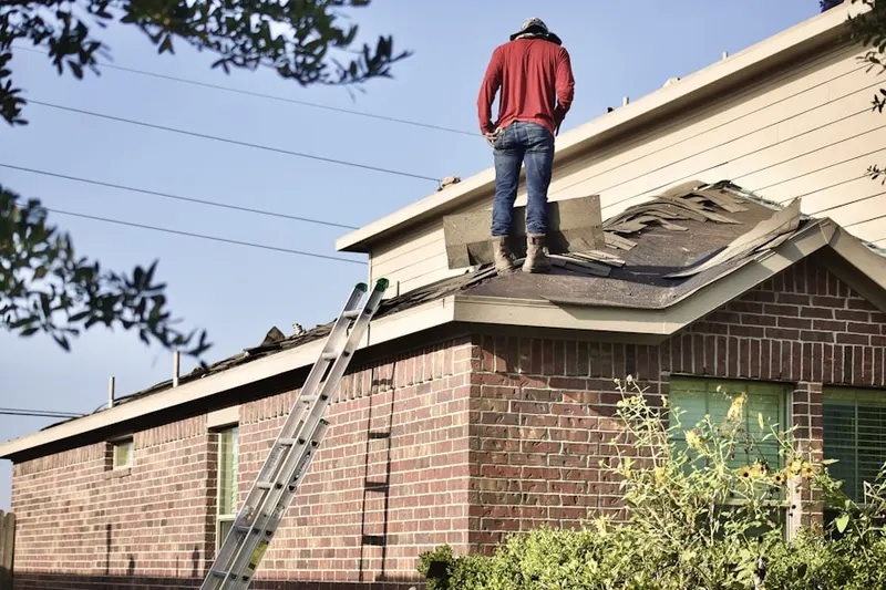 Professional roofer working on a residential roof in Loretto